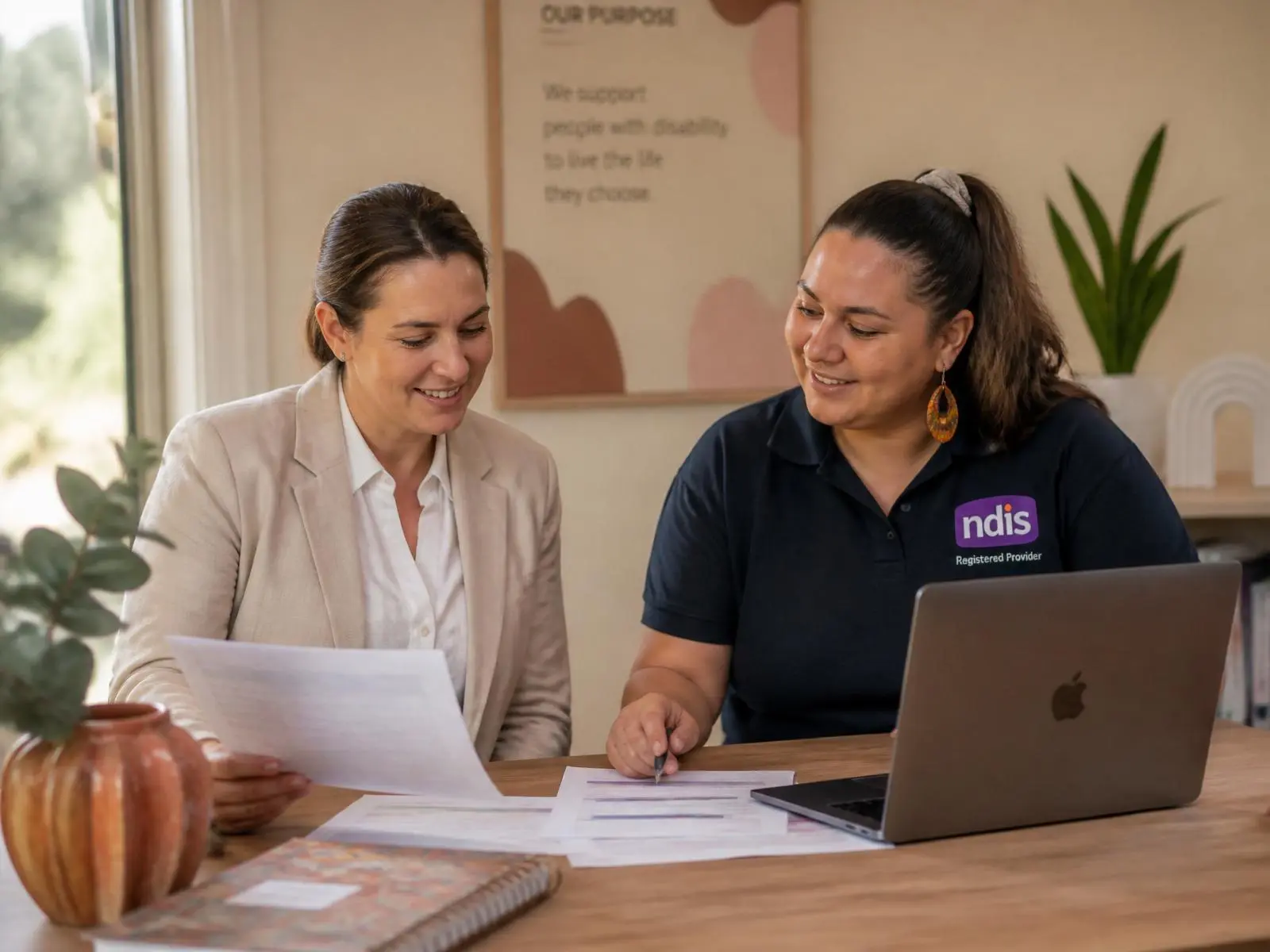 A support worker sharing a warm moment with a participant in a bright community centre